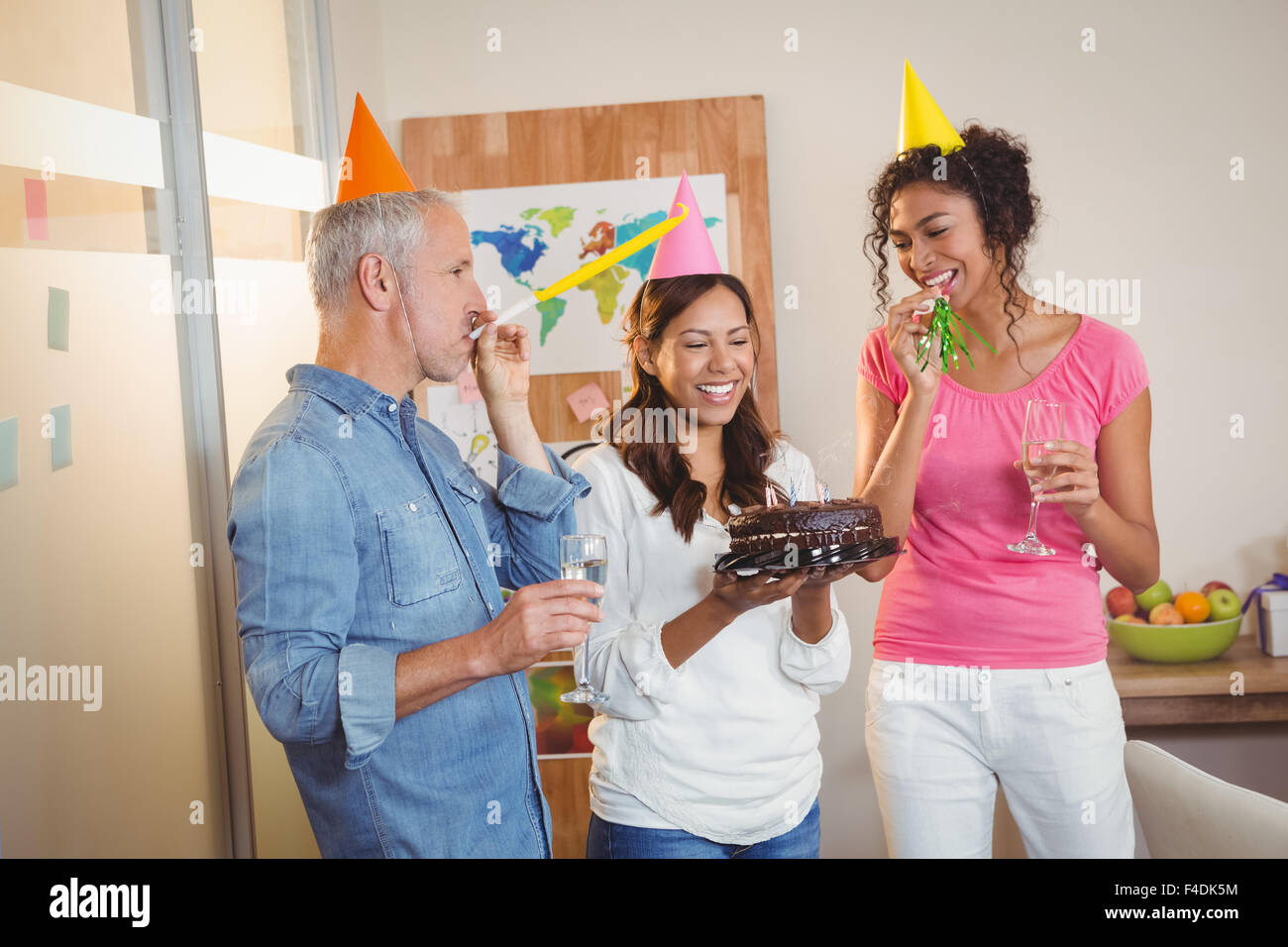 Kollegen, die Geburtstagsfeier der Geschäftsfrau Partei Horn bläst Stockfoto