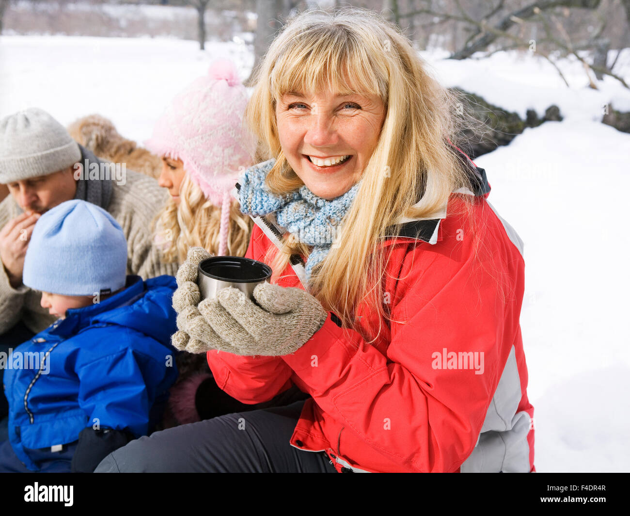 Eine Frau an einem Winter-Picknick mit ihrer Familie. Stockfoto