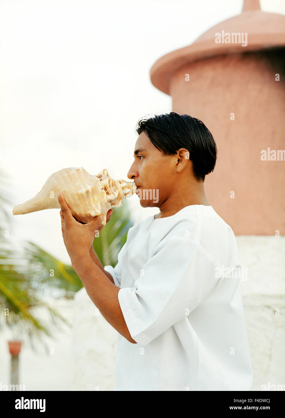 Ein mexikanischer Mitarbeiter bläst eine Muschel während eines Rituals Temazcal im Maroma Spa and Resort. Riviera Maya, Yucatan, Mexiko. Stockfoto