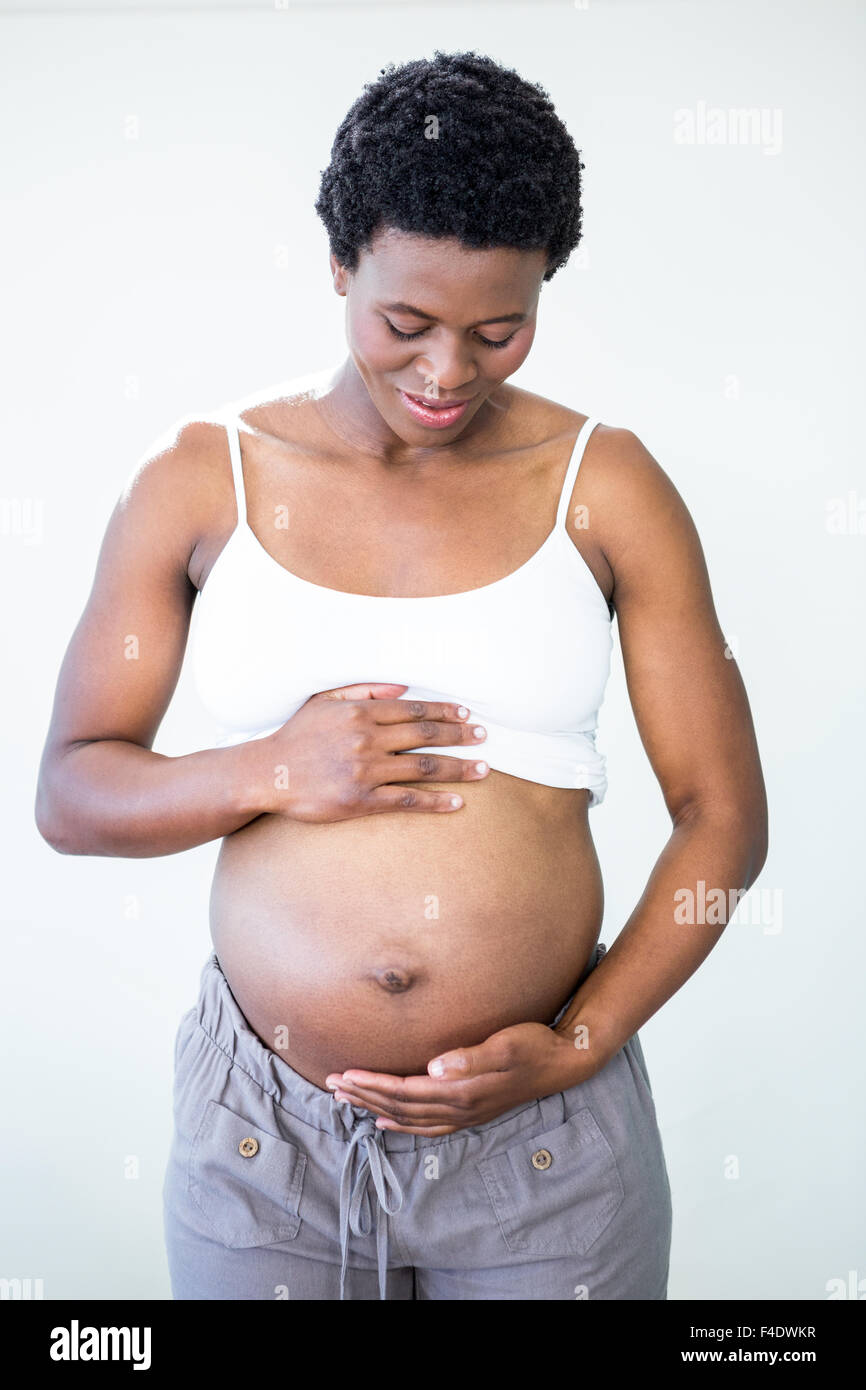 Glückliche Frau reibt ihren schwangeren Bauch Stockfoto