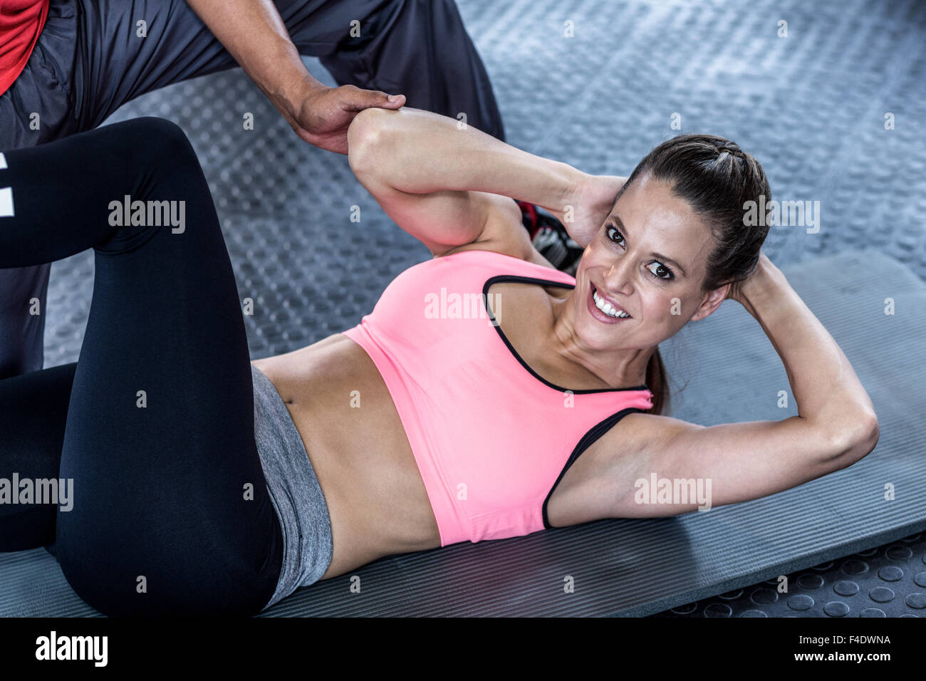 Männlichen Trainer unterstützen Frau mit Bauch-crunches Stockfoto