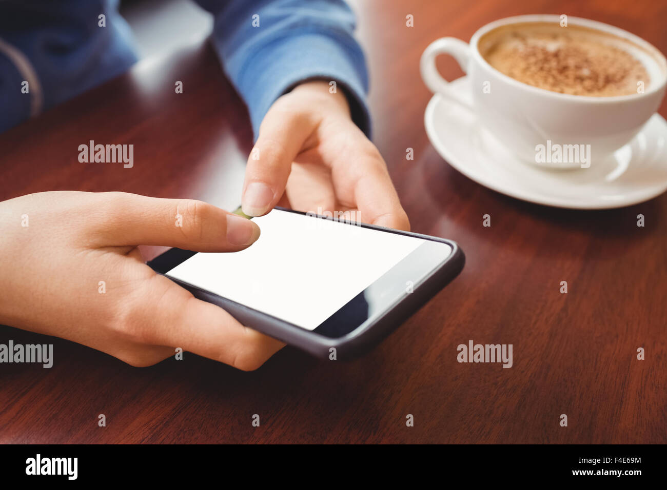 Frau mit ihrem Smartphone mit Kaffee Stockfoto