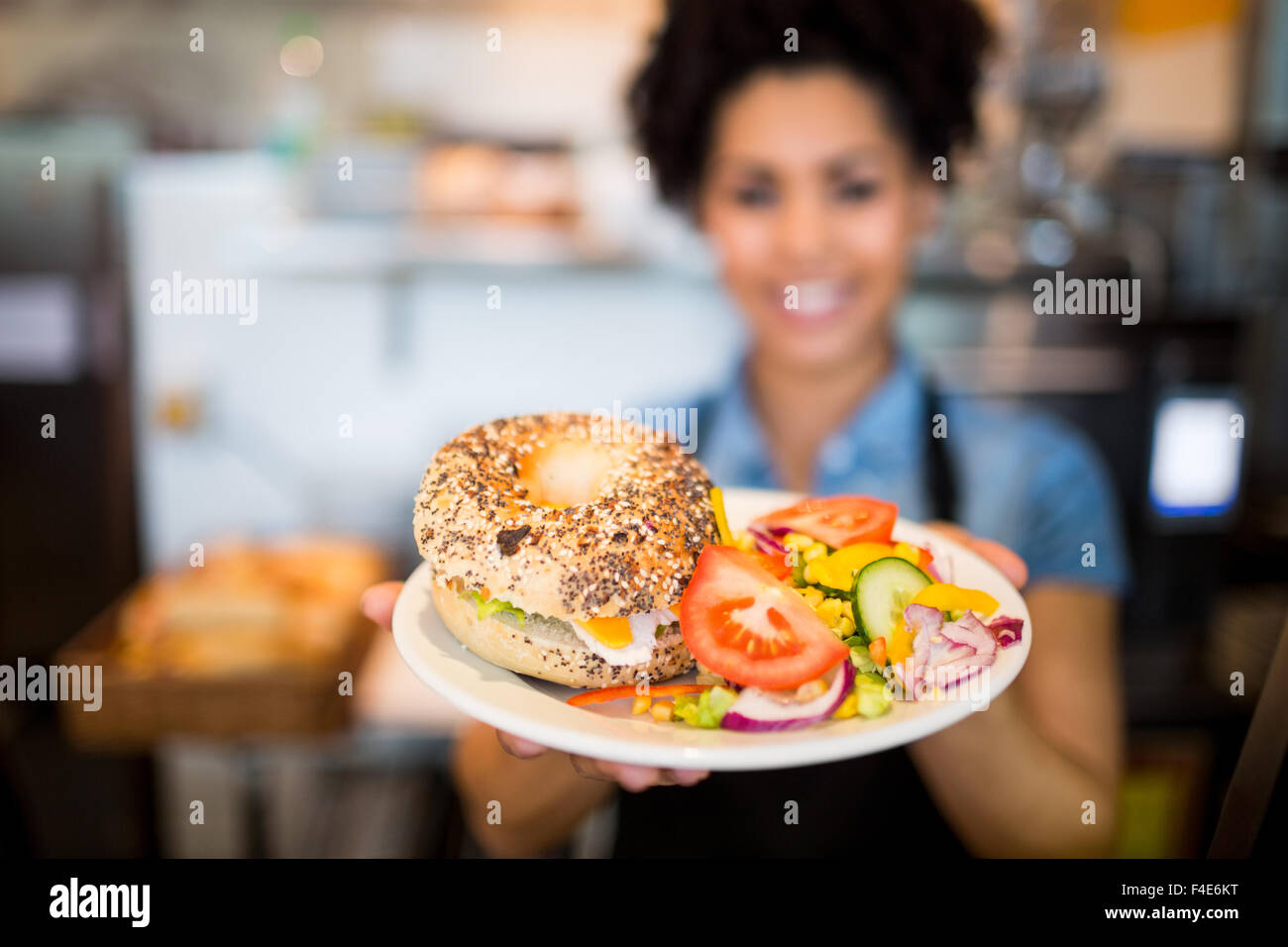 Hübsche Kellnerin das Mittagessen an Kamera Stockfoto