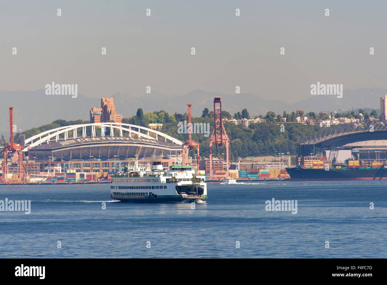 USA, Bundesstaat Washington, Seattle. Washington State Ferry kreuzt Elliott Bay vor Jahrhundert-Link-Feld und Hafen von Seattle. Stockfoto