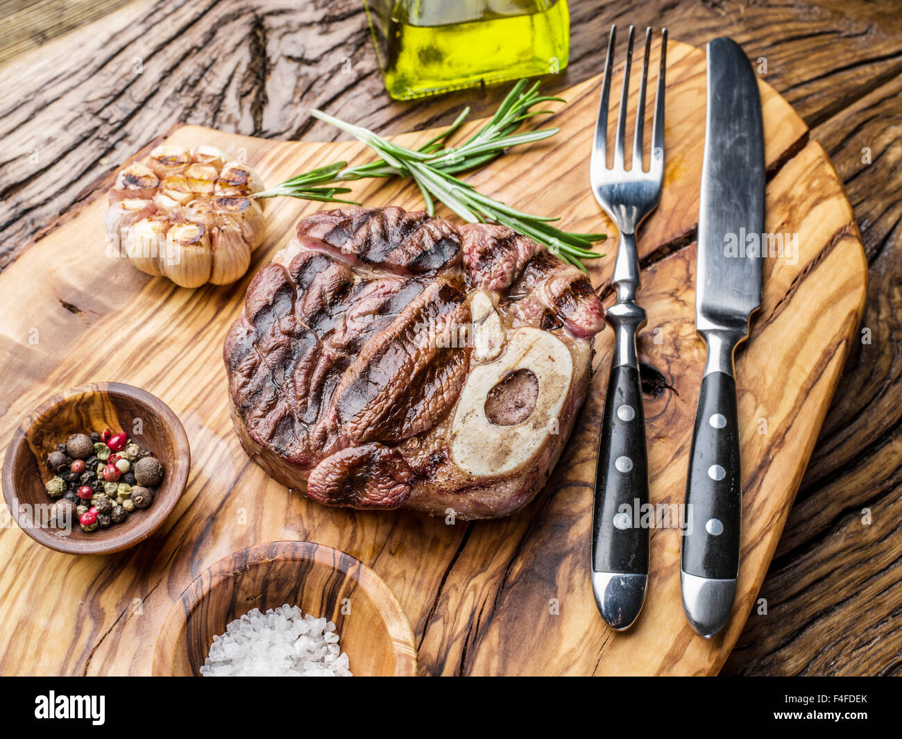 Rindersteaks mit Gewürzen auf einem Holztablett. Stockfoto