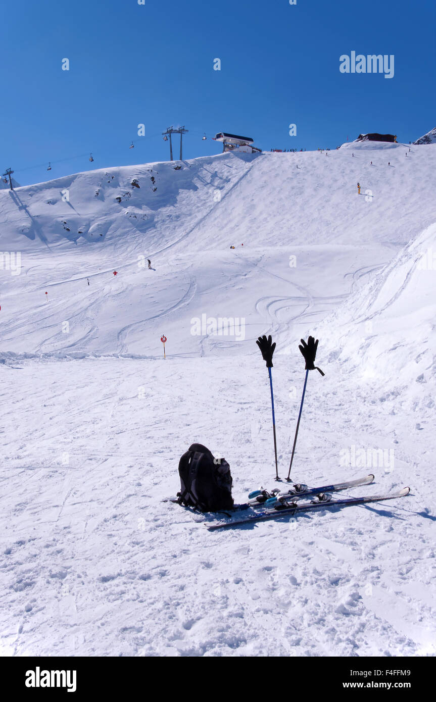 Ein paar Ski, Skistöcke mit Handschuhen und einem Rucksack in der Nähe von Skipisten und Liftanlagen im Skigebiet Sölden in Österreichische Alpen Stockfoto