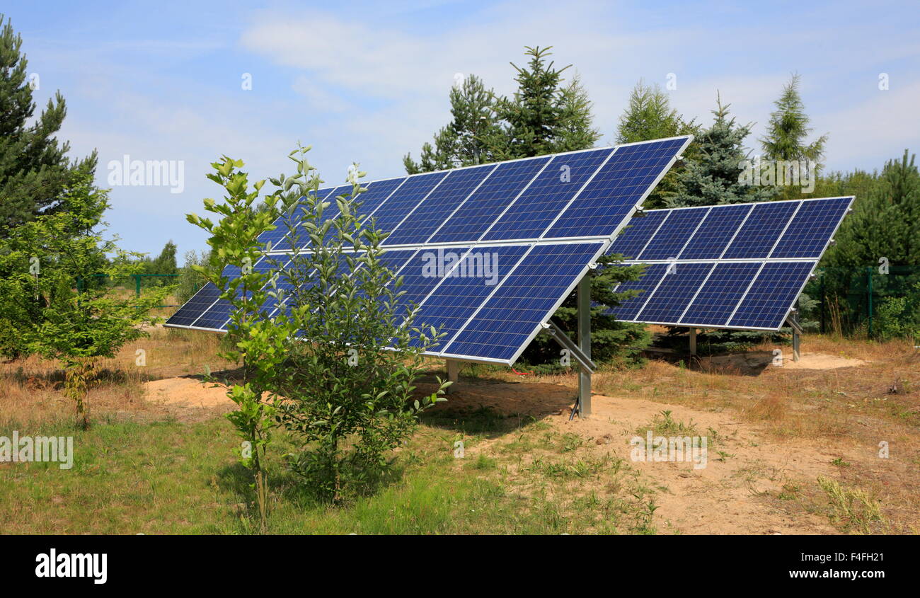 Zwei Photovoltaik-Module setzen im Garten gegen Bäume und blauer Himmel Stockfoto