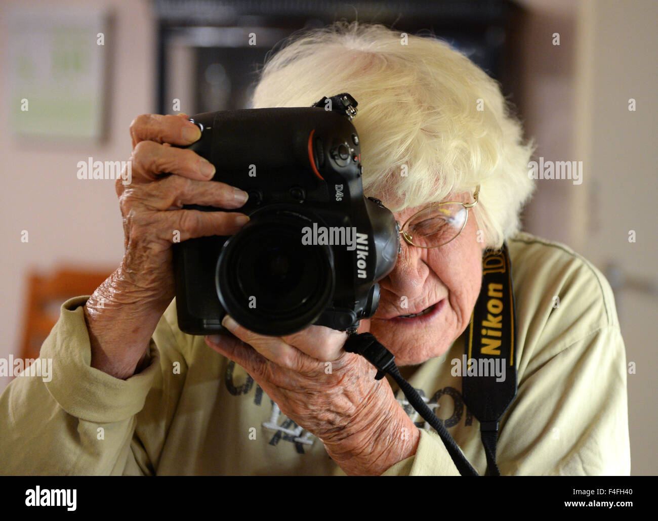 Resident Kaethe Wagner nimmt ein Bild mit der Kamera in ihre gemeinsame Wohnung für Patienten mit Demenz in Berlin, Deutschland, 16. Oktober 2015. Zehntausende von Menschen haben eine Petition gegen die Kündigung des Mietvertrages von der Wohngemeinschaft eingereicht. Foto: Britta Pedersen/dpa Stockfoto