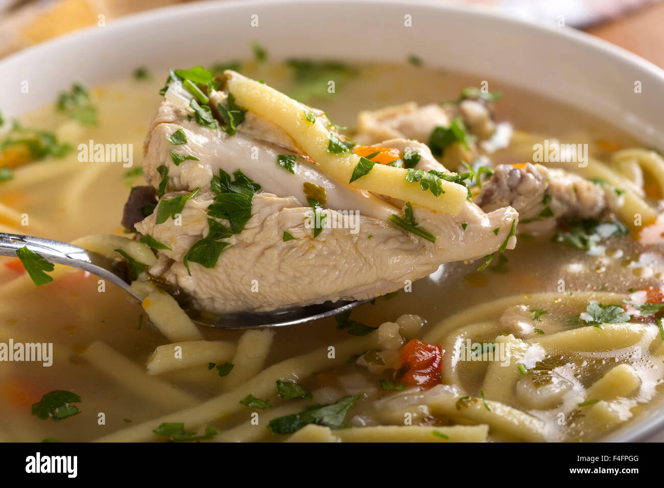 Nahaufnahme der Löffel mit Hühnersuppe mit Gemüse und Nudeln Stockfoto