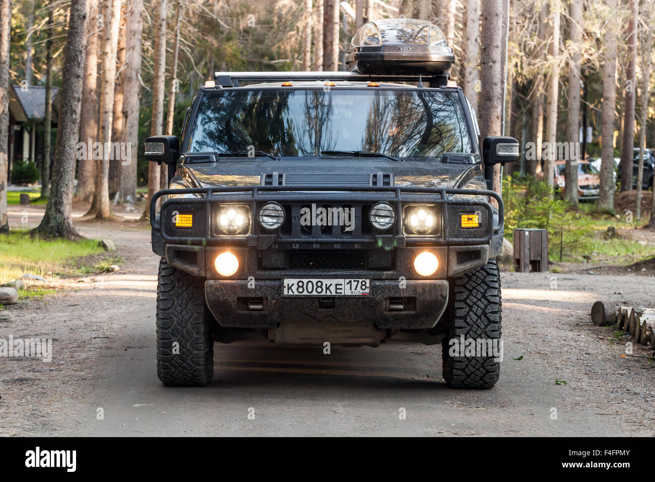Sankt-Petersburg, Russland-11. Oktober 2015: Schwarz Hummer H2 Fahrzeug auf schmutzige Landstraße im russischen Wald, Vorderansicht geht Stockfoto