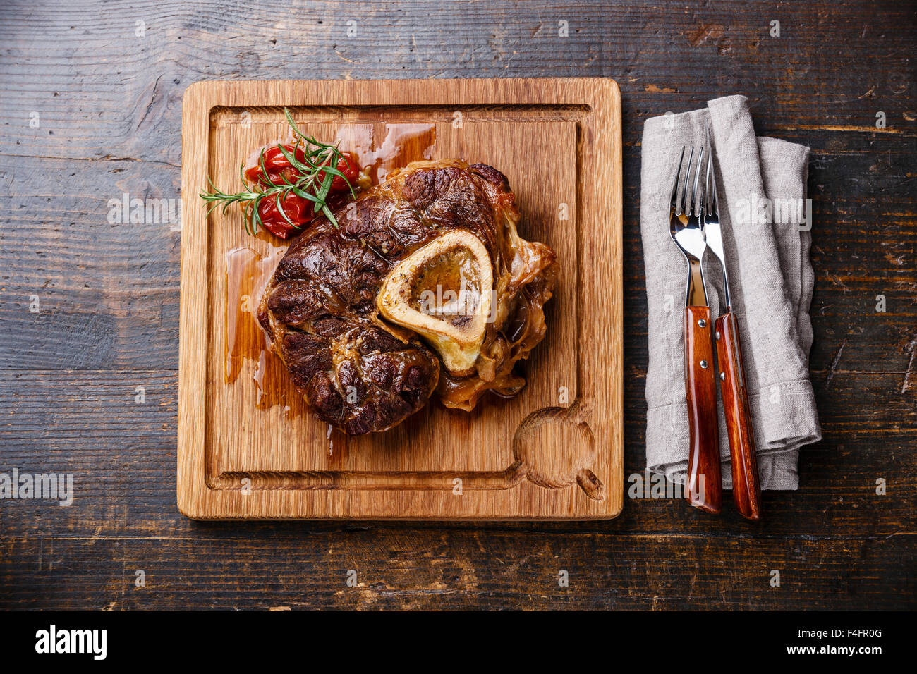 Fertig zubereitete Ossobuco Kalbshaxe auf dem Board auf hölzernen Hintergrund Stockfoto