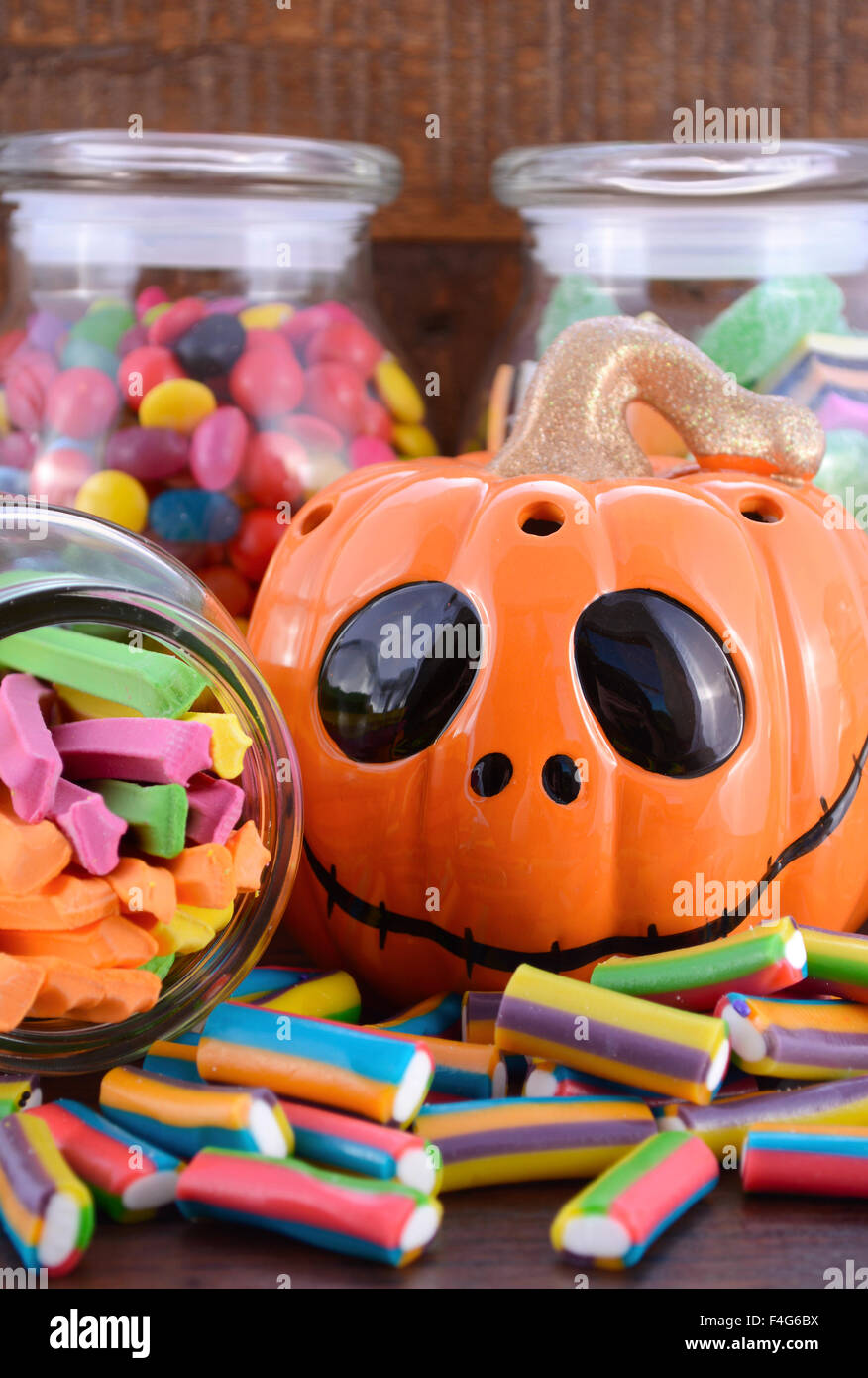 Happy Halloween-Süßigkeiten in Gläsern Apotheker mit orange Kürbis Jack O Lantern Closeup auf dunklen Holztisch. Stockfoto