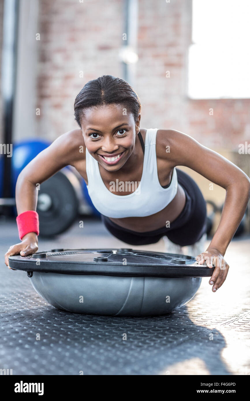 Muskuläre lächelnde Frau dabei Fitnesstraining Stockfoto