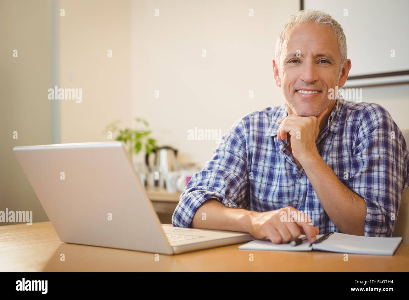 Glücklich kreative Geschäftsmann mit Hand am Kinn im Büro Stockfoto