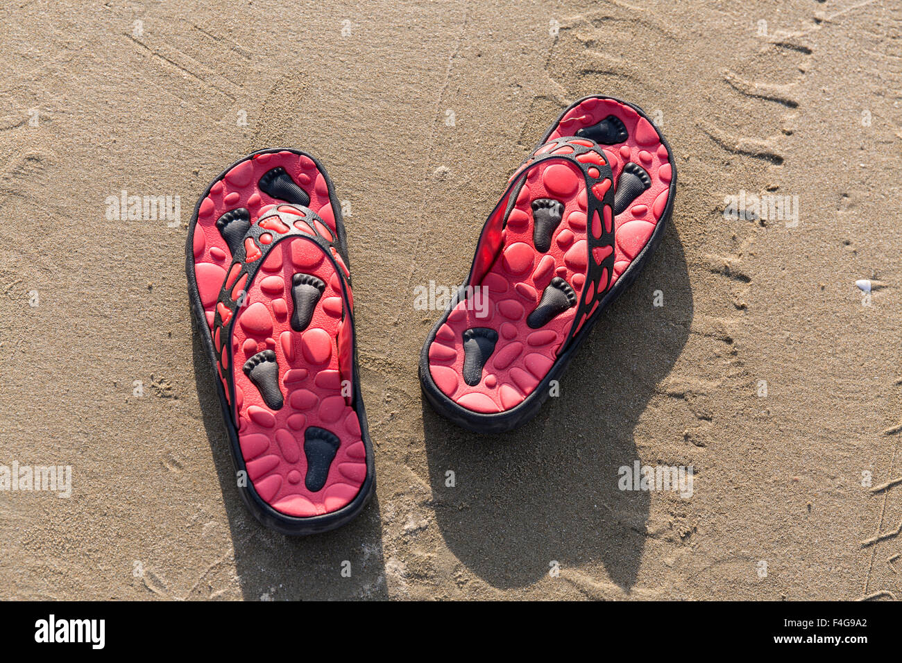 Schöne Flipflops im Sand am Strand von Thailand Stockfoto