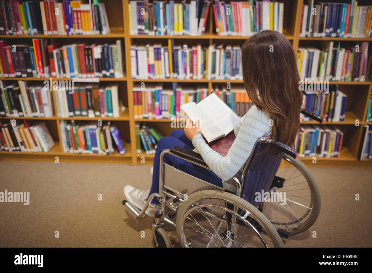 Behinderten Schüler Buch auf Rollstuhl Stockfoto