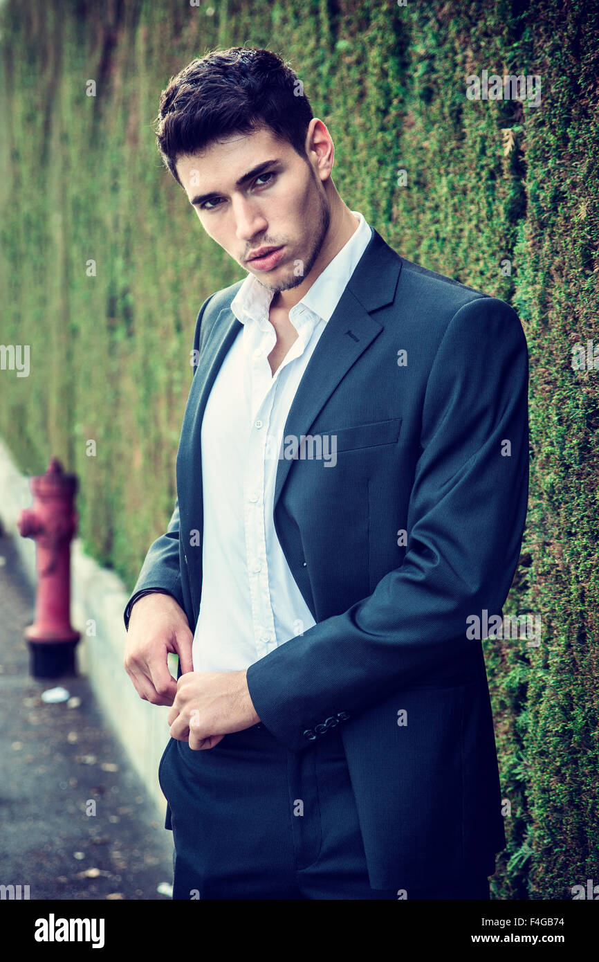 Hübscher junger Mann in eleganten Business-Anzug stehen im Freien in Straße Blick in die Kamera Stockfoto
