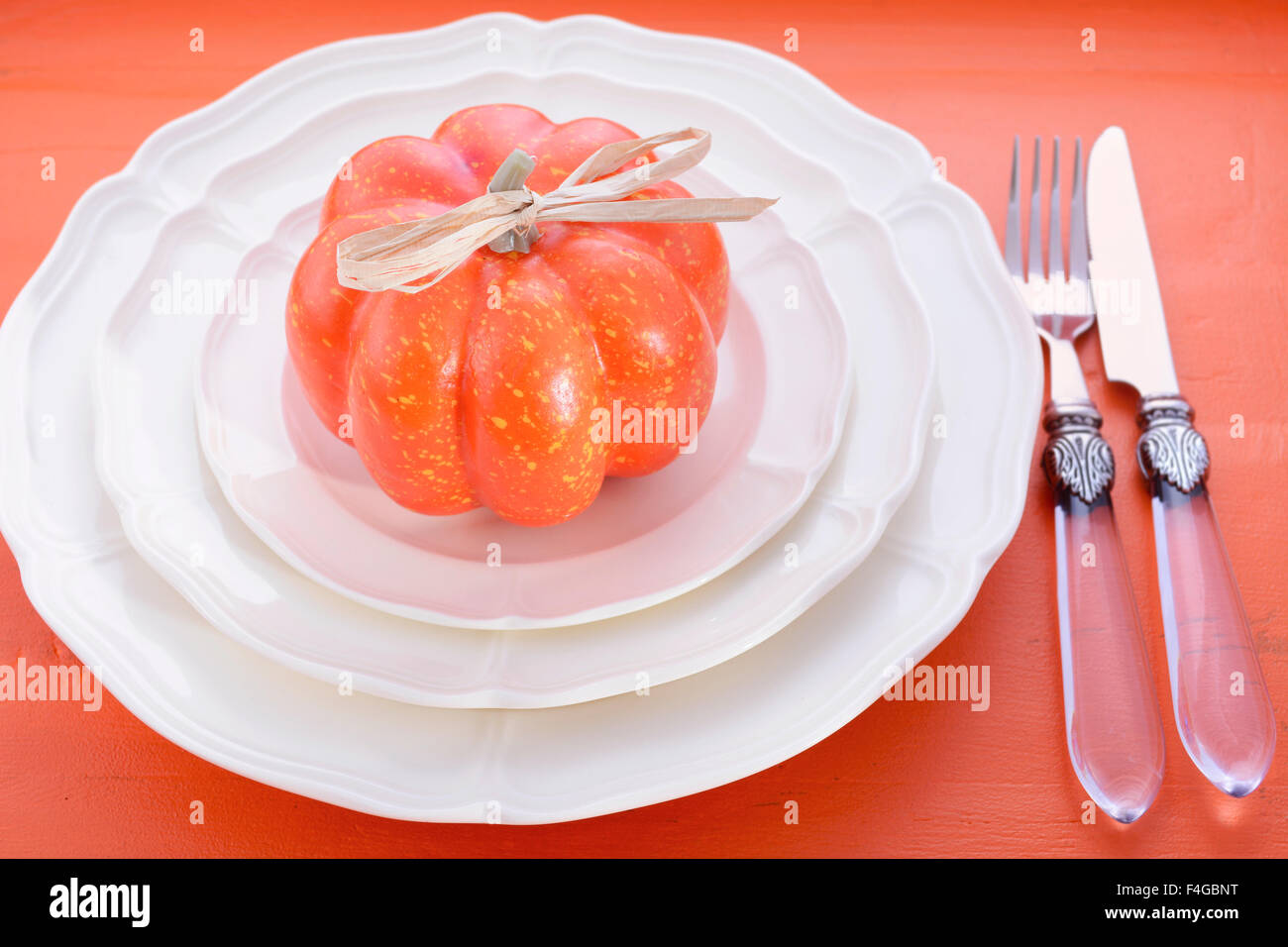 Halloween oder Thanksgiving formalen Ort Tischdekoration mit Kürbis und Vintage Besteck und feines Porzellanteller auf rustikalen orange Stockfoto