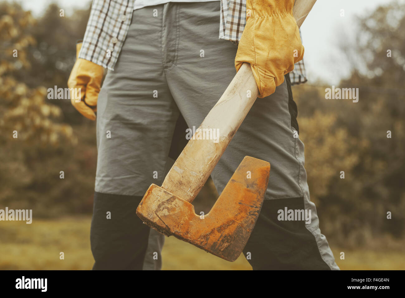 Ernsthafte zuversichtlich Holzfäller, erwachsenen Mann, der eine große Axt in Umgebung im freien Stockfoto