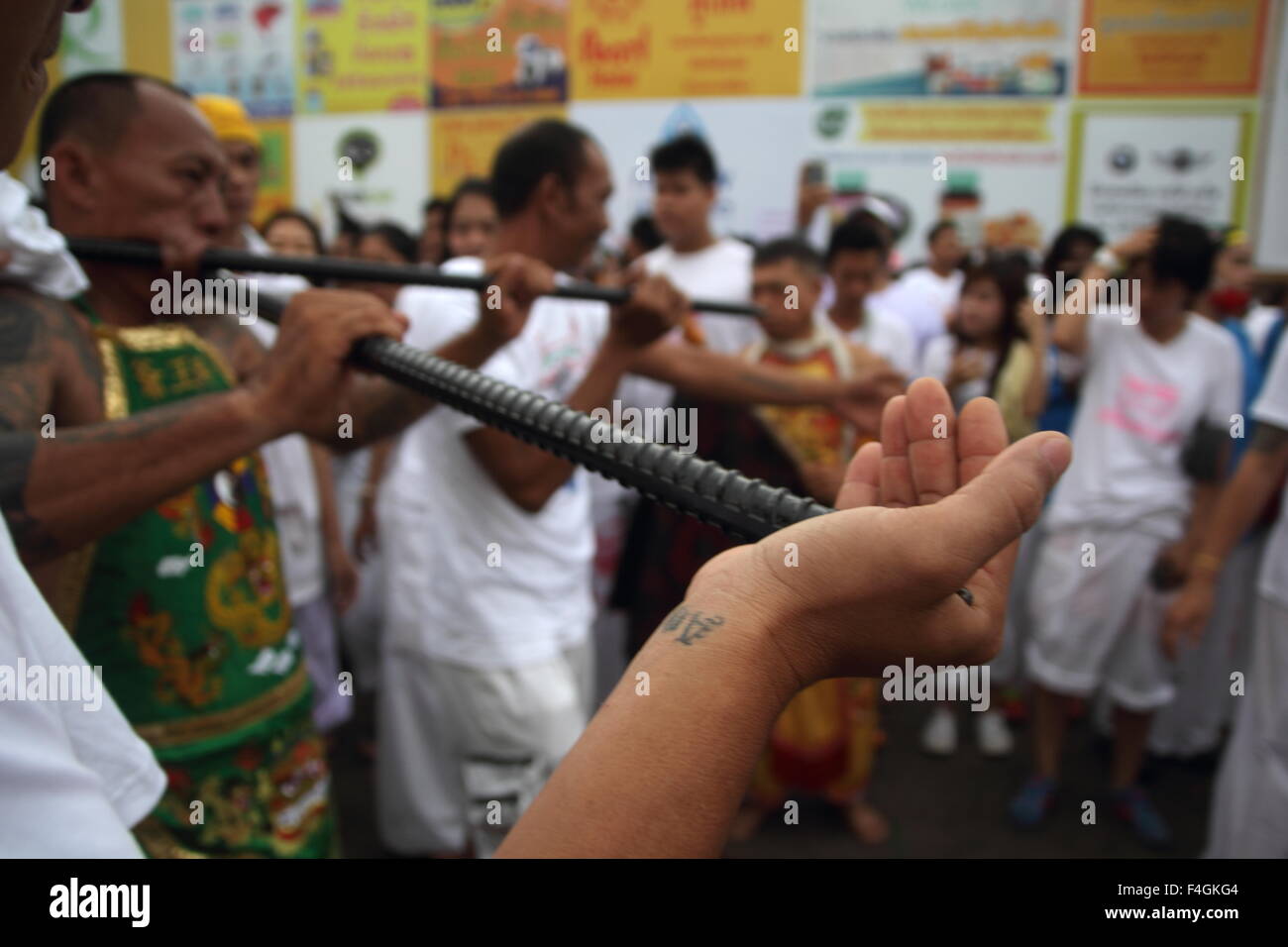 Phuket, Thailand. 18. Oktober 2015. Ein Anhänger von den chinesischen Bang Neow Schrein mit Rundstab Preis in seine Wangen nimmt an einer Straße Prozession während der Phuket Vegetarian Festival teil. Das Phuket Vegetarian Festival beginnt am ersten Abend des neunten Mondmonats und dauert neun Tage, religiöse Anhänger Schrägstrich selbst mit Schwertern, ihre Wangen mit scharfen Gegenständen durchbohren und begehen andere schmerzhafte um sich zu reinigen. Bildnachweis: John Vincent/Alamy Live-Nachrichten Stockfoto