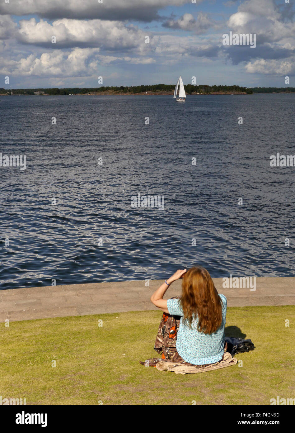 Junge Frau, Blick auf das Meer auf die Insel-Festung Suomenlinna, in Helsinki, Finnland Stockfoto