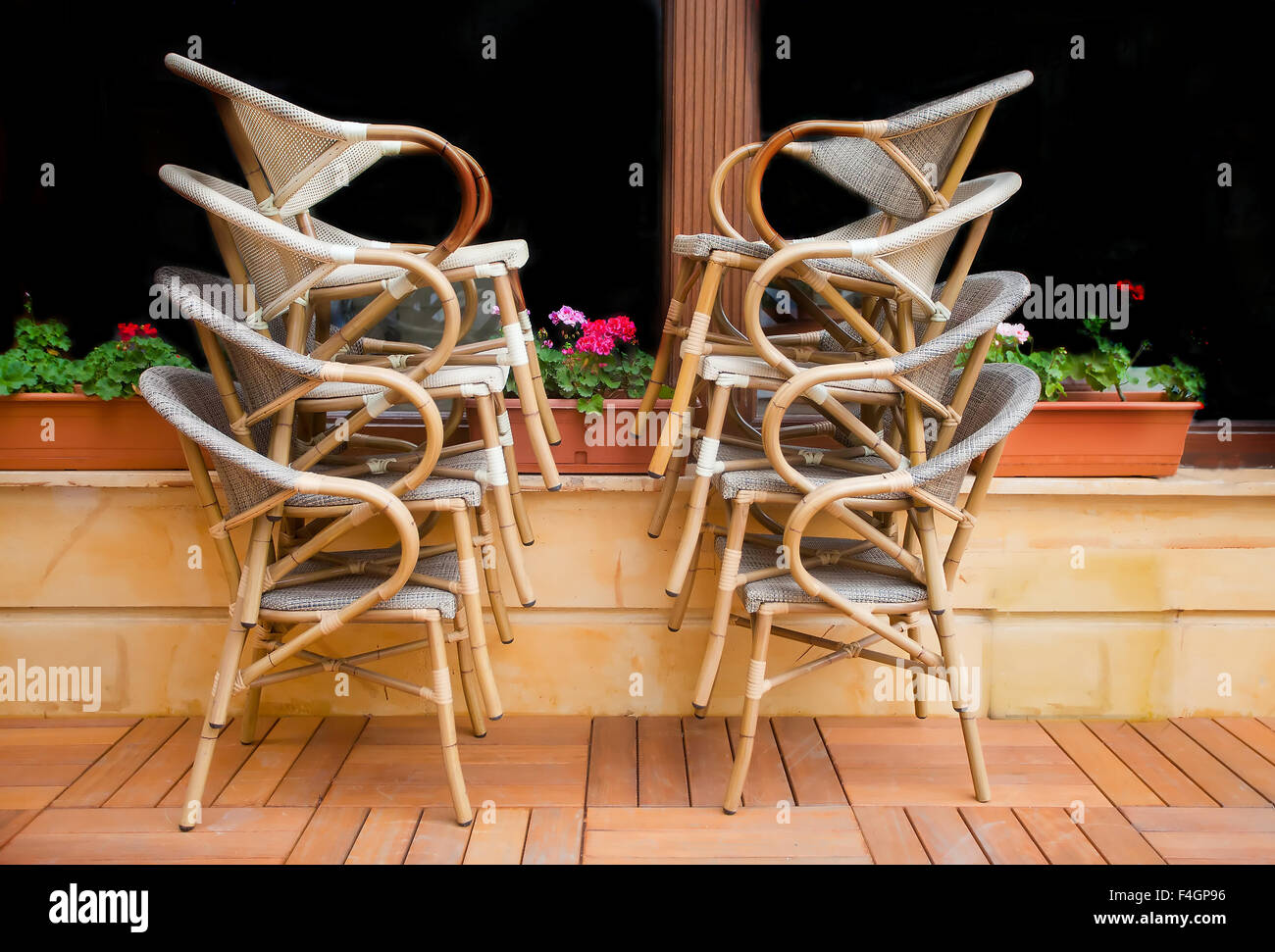 Aufgetürmt Stroh Stühle vor einem dunklen Fenster einen Kaffee Platz vor Eröffnung Stockfoto
