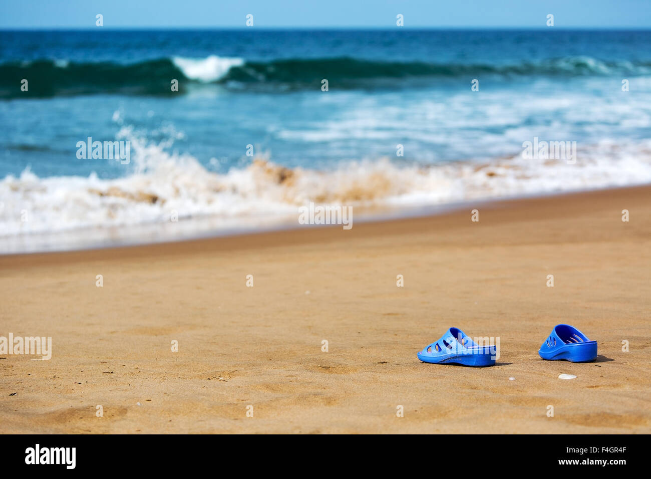 Blaue Damenschlappen am Meer Sandstrand, Sommer Urlaub Konzept Stockfoto