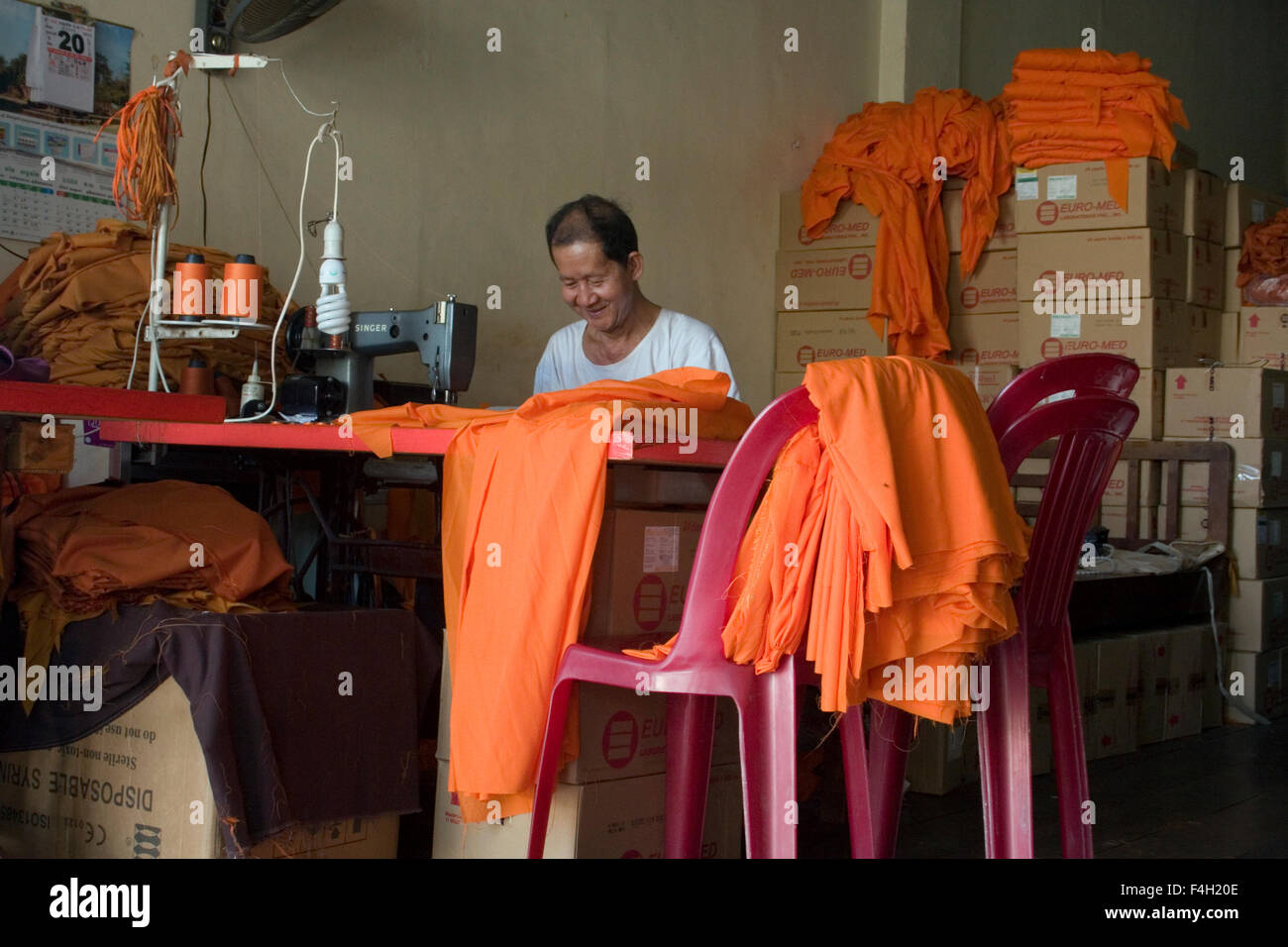 Ein Mann macht Safran Roben für buddhistische Mönche in einem Geschäft in Kampong Cham, Kambodscha. Stockfoto