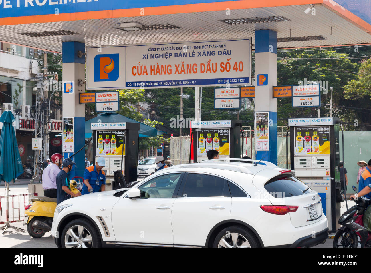 Auto und Roller Stop für Kraftstoff an einer Tankstelle Petrolimex im Zentrum von Ho-Chi-Minh-Stadt, Vietnam Stockfoto