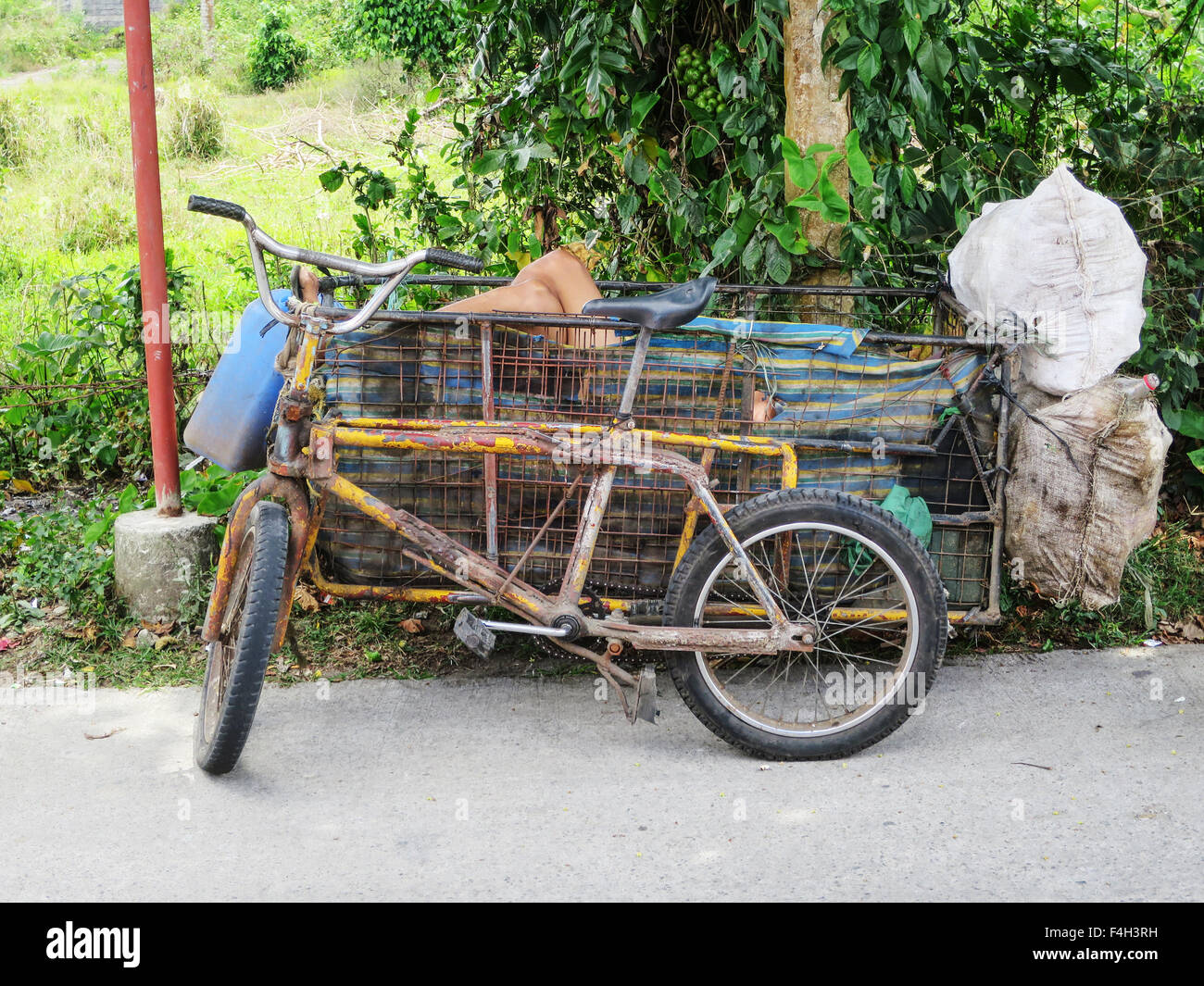 Ein Filipino Mann nimmt eine Siesta am Nachmittag von seiner Arbeit sammeln Flaschen in den Beiwagen seines Fahrrades. Stockfoto