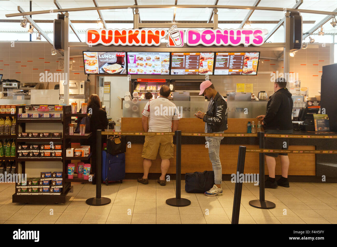 Menschen in einer Warteschlange bei Dunkin Donuts-Fastfood-Restaurant, das Terminal, Flughafen Boston, USA Stockfoto