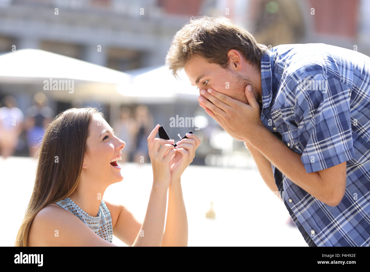 Vorschlag von einer Frau mit einem Mann in der Mitte einer Straße zu heiraten Stockfoto