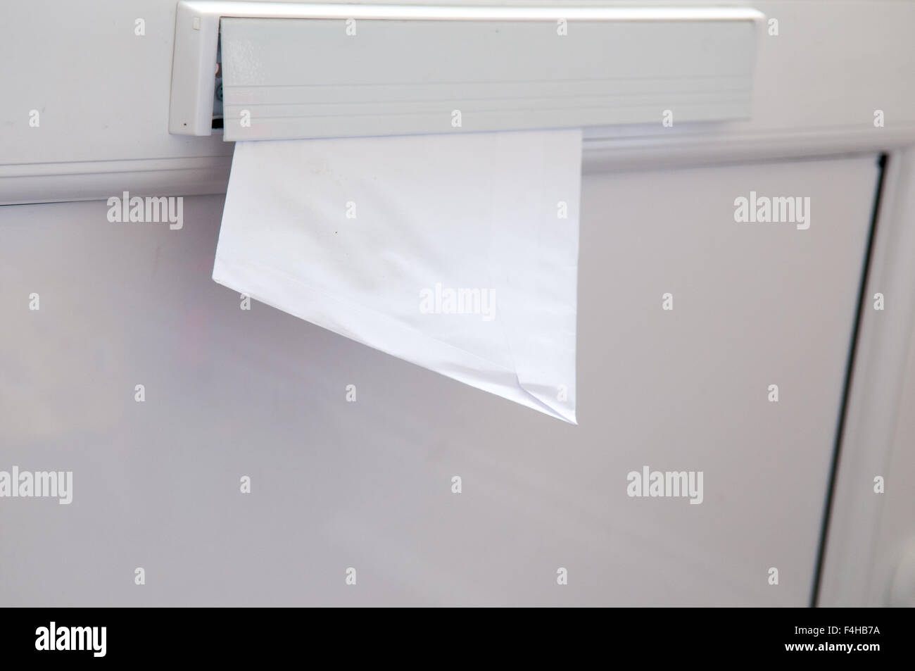 Ungeöffnete Brief wird durch einen Briefkasten Stockfoto