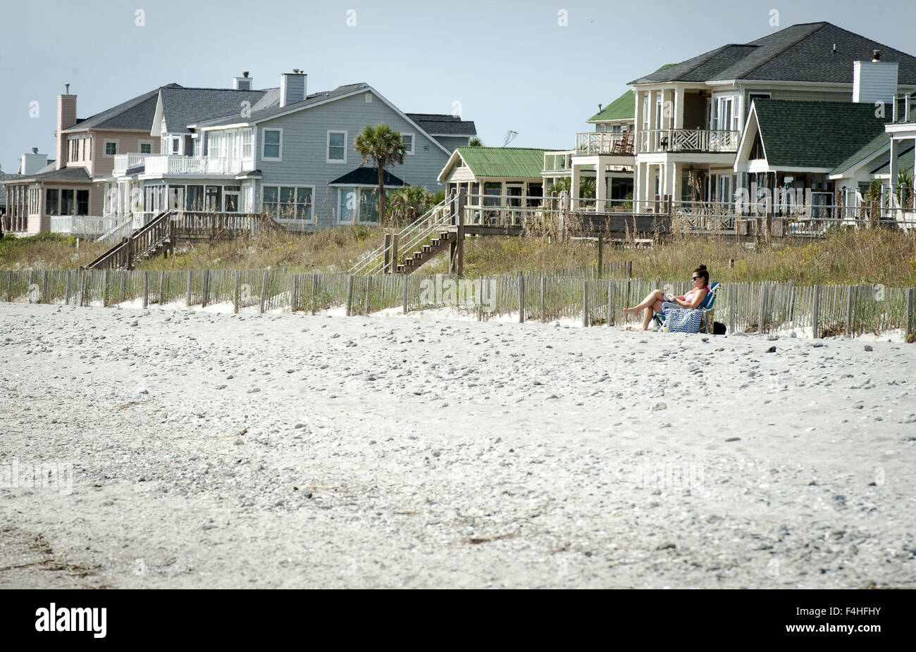 Folly Beach, South Carolina, USA. 17. Oktober 2015. Mehrfarbige Strandhäuser lehnen Sie sich zurück in den Dünen entlang Folly Beach, South Carolina, südlich von Charleston. Folly Beach gehört zu mehreren Bereichen entlang der Küste in der Nähe von Charleston mit Strandhäuser, Ferienhäuser und Wohnungen für Ferien und Wochenenden als Zweitwohnungen verwendet. Farben und Layout variieren mit den meisten Designs, Low-Profile-Traufe, Fensterläden und robuste Bauweise, Berücksichtigung Konto rauen Wetter, starker Wind und Regen einschließlich Hurrikane. Viele Häuser entscheiden, Holzstege um niedrige Wanderdünen und Seegras mit Treppen Geschw überspannen angesprochen haben Stockfoto