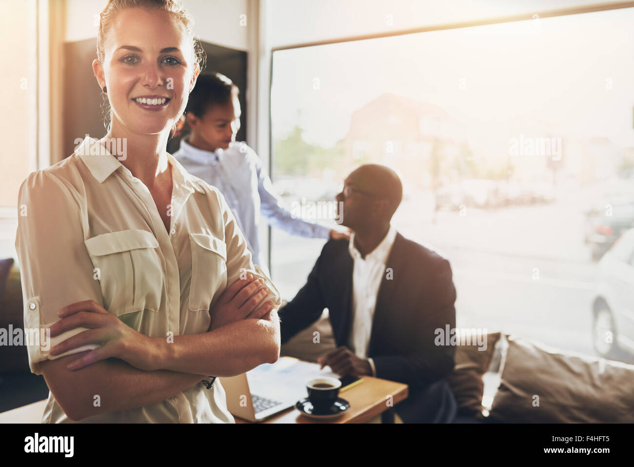 Weibliche Business-Frau, stand vor Kollegen in kleinen Büroräumen Stockfoto