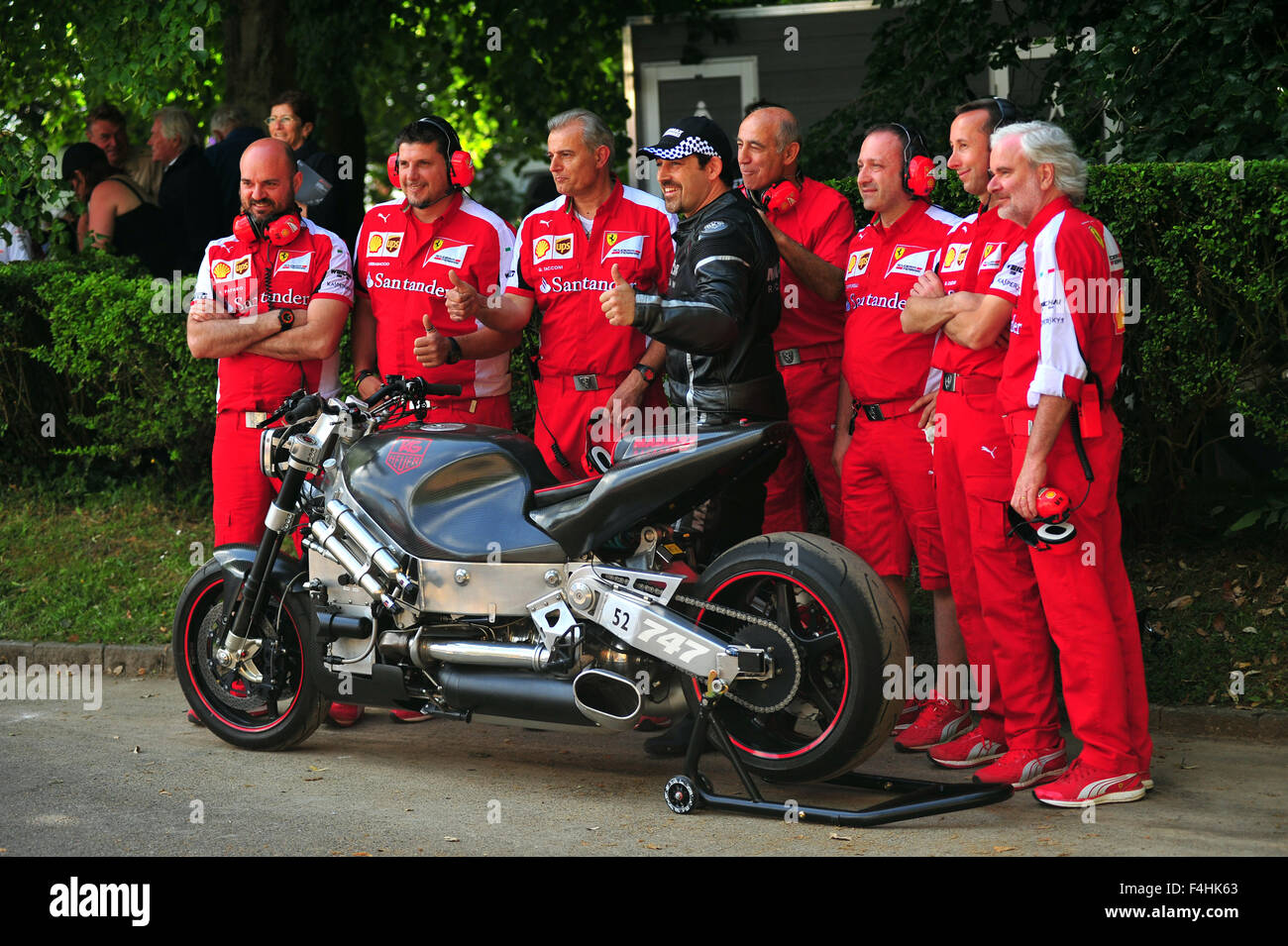 Ferrari F1 Team Mechaniker posieren mit dem Madmax Team Turbine Rennmotorrad auf dem Goodwood Festival of Speed im Vereinigten Königreich. Stockfoto