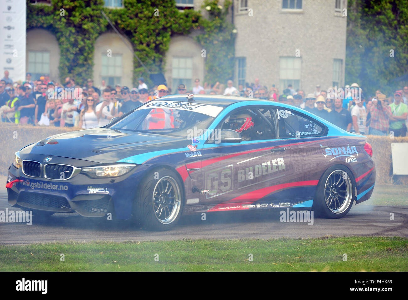 Ein moderner BMW raucht seine Reifen auf dem Goodwood Festival of Speed im Vereinigten Königreich. Stockfoto