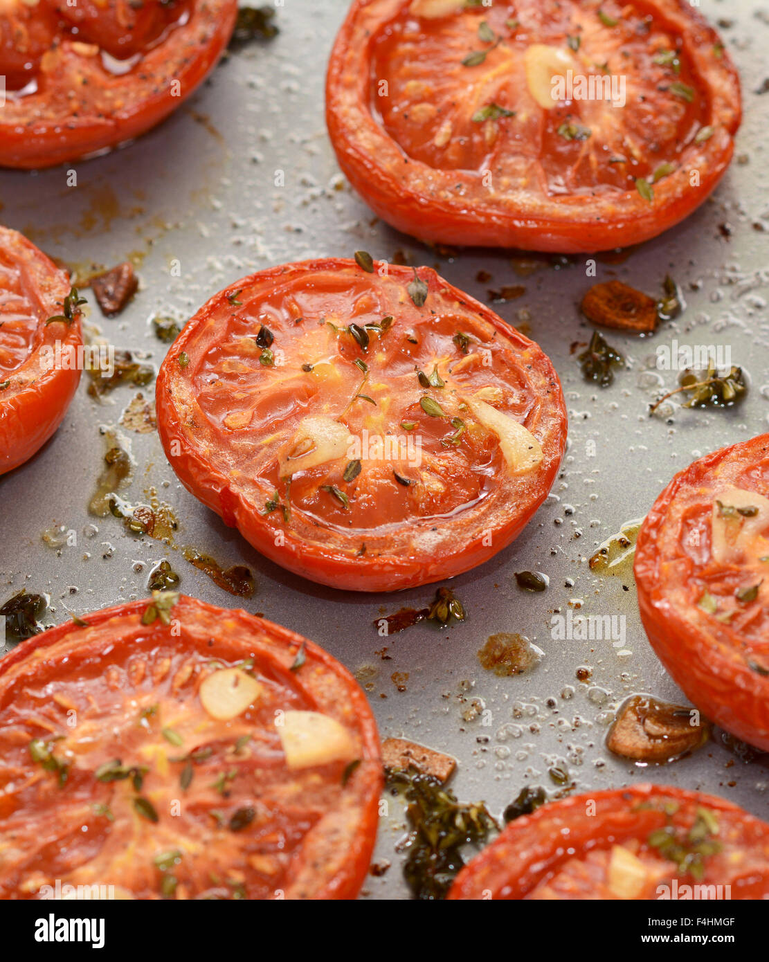 Nahaufnahme von gebratenen Tomaten, gewürzt mit Thymian und Knoblauch Stockfoto