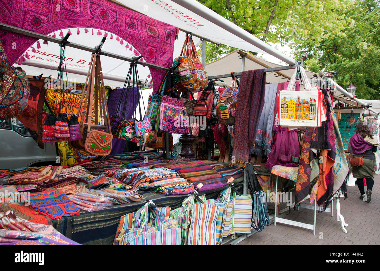 Wild bunte Textilien locken Käufer auf dem Waterlooplein Flohmarkt im Zentrum von Amsterdam. Stockfoto
