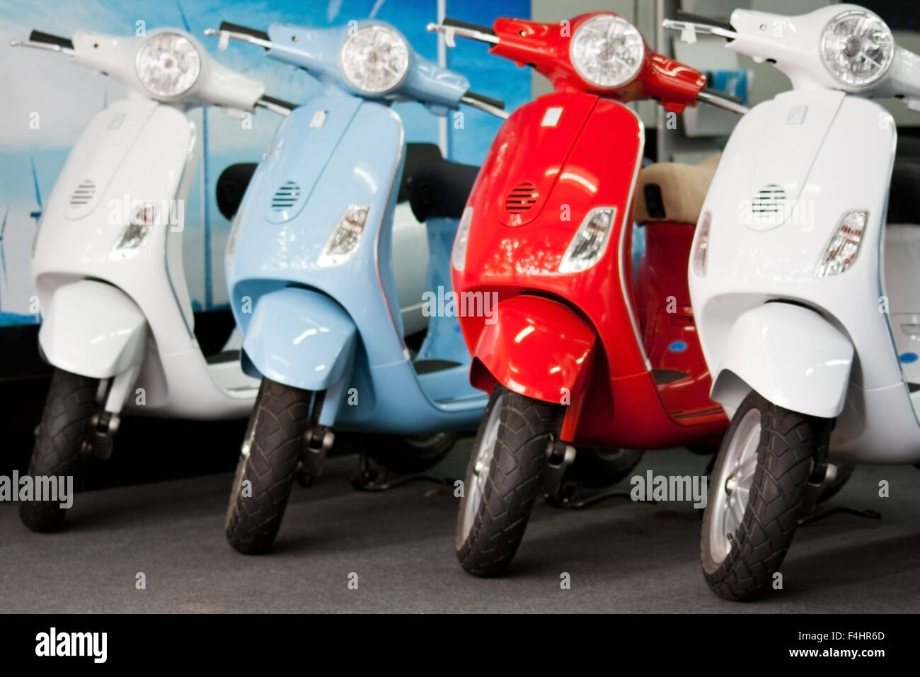 Vier verschiedene farbige Vespa Roller im Showroom, neu, makellos sauber, makellos, Kühlen, eleganten, stilvollen italienischen Mopeds und kultigen Beförderungsmittel Stockfoto