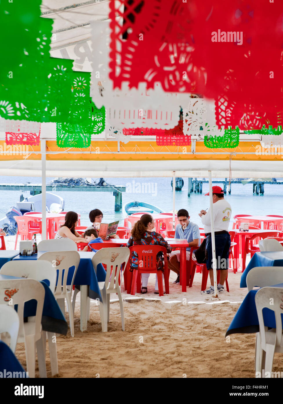 Kunden geben ihre Bestellung auf Minino, unter freiem Himmel, Zelt-Stil-Meeresfrüchte-Restaurant in der Nähe der Docks von Isla Mujeres, Mexiko Stockfoto