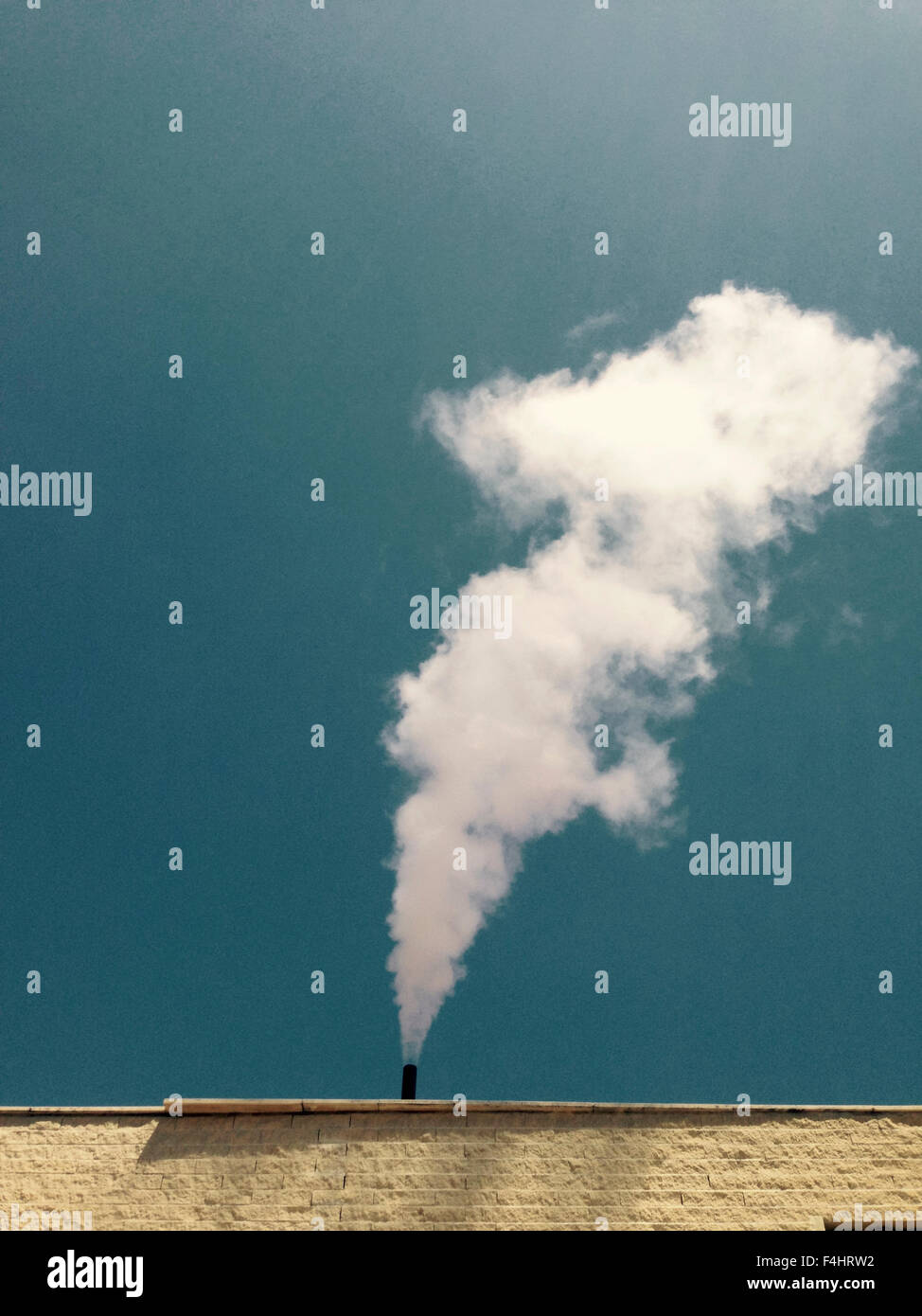 Industrielle Wäsche Schornstein spuckt weißen beschlagen Wolke vertikal über blauen Himmel Stockfoto