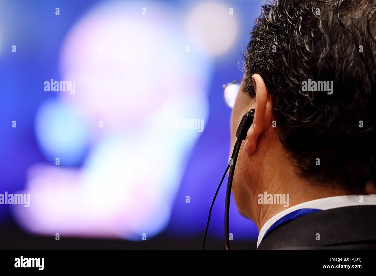 Nicht erkennbare Mann mit in-Ear-Kopfhörer für Übersetzung während der Veranstaltung Stockfoto