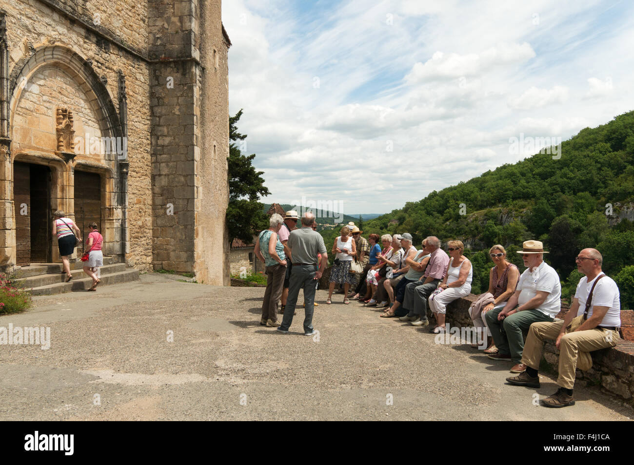 Besucher saßen außerhalb der Kirche Saint-Cirq-Lapopie, Midi-Pyrénées, Frankreich Stockfoto