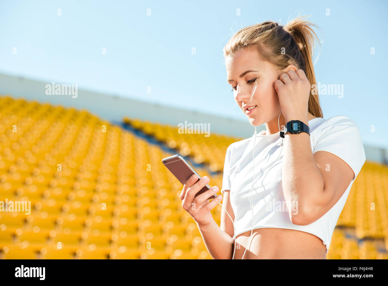 Porträt einer Sport-Frau mit Smartphone auf Stadion Stockfoto