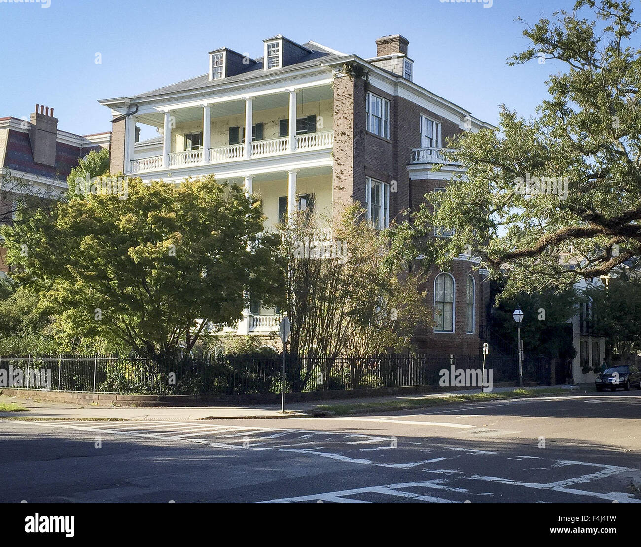 Charleston, South Carolina, USA. 16. Oktober 2015. Die Stadt Charleston South Carolina hat viele stattliche und traditionelle Häuser aus Stein, Ziegel und Schindeln oder Stufenfalz stehen noch aus der Zeit vor dem amerikanischen Bürgerkrieg sowie im amerikanischen Unabhängigkeitskrieg. Die meisten Häuser folgen einem ähnliches Muster von privaten und öffentlichen Bereichen, einschließlich Seite Balkone nutzen dessen, was heute noch den vorherrschenden Winden aus dem Atlantischen Ozean. ---Auf dem Foto sitzt ein stattliches Charleston-Haus an der Ecke der Meeting Street und Batterie Sudstraßen gegenüber White Point Garden in der Innenstadt Stockfoto