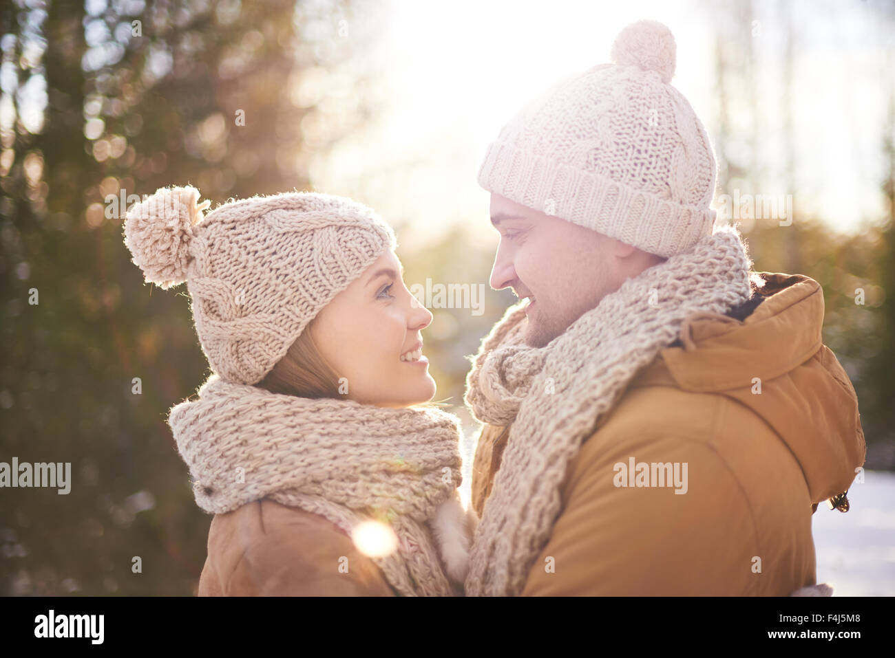 Glücklicher junger Mann und Frau einander an Wintertag betrachten Stockfoto