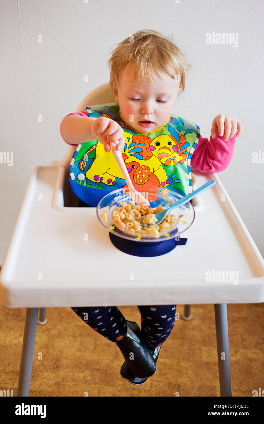 Mädchen sitzen in einem Hochstuhl Essen, Schweden. Stockfoto