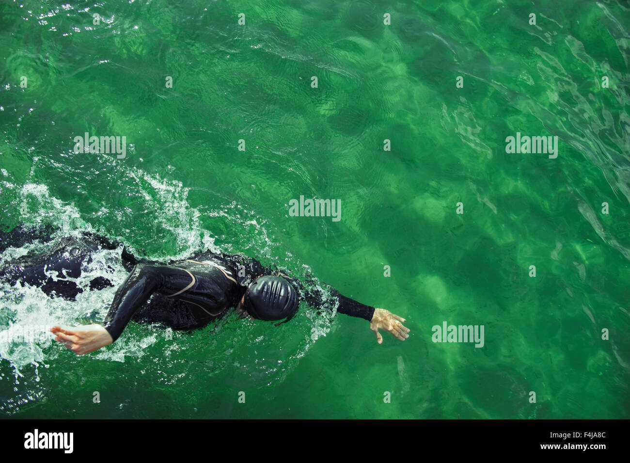 Frau, Schwimmen im türkisblauen Wasser in einen Taucheranzug, Schweden. Stockfoto