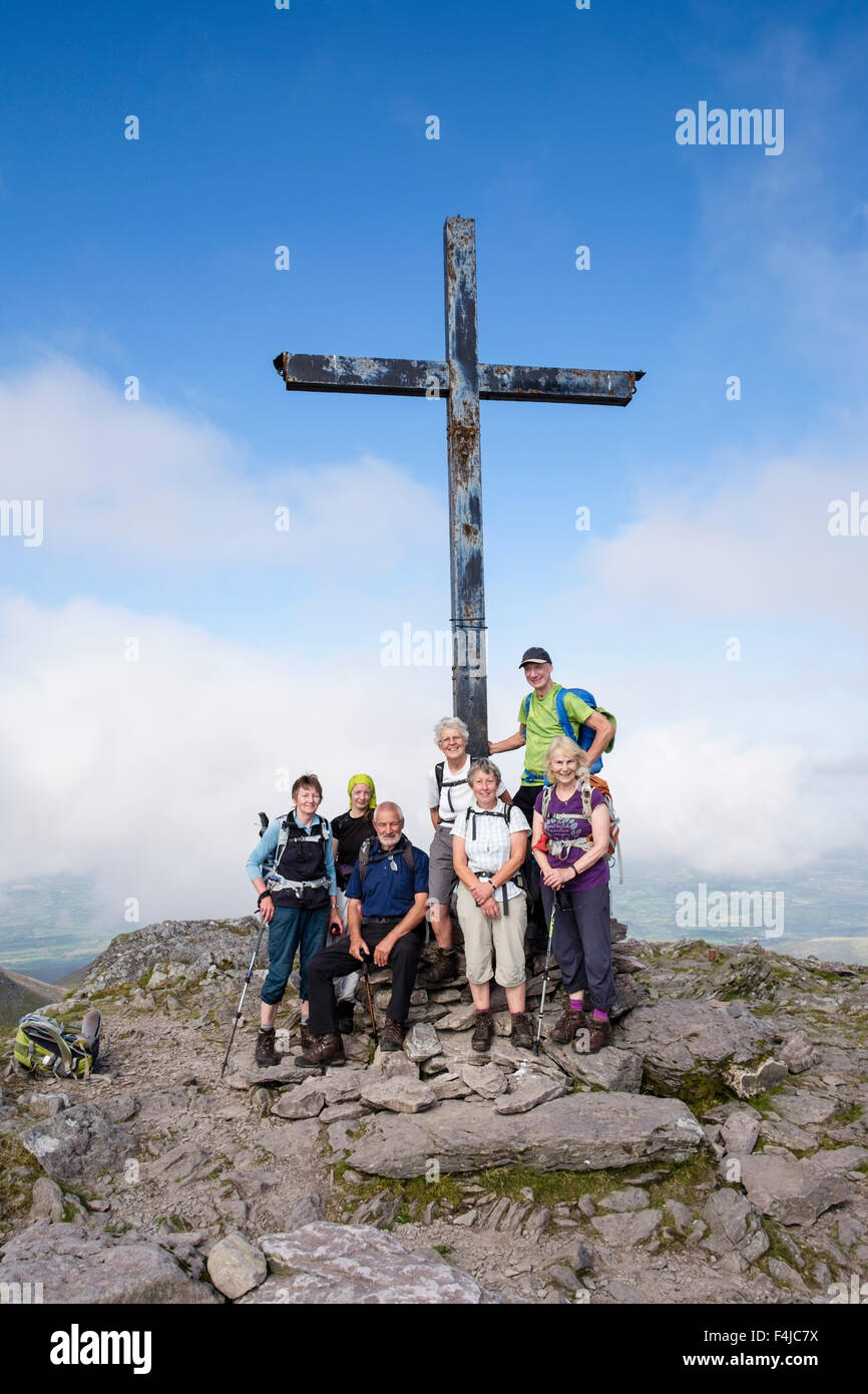 Wanderer zusammen mit eisernen Kreuz Kreuz auf den Carrauntoohil Mountain Summit in MacGillycuddy Reeks, County Kerry, Irland, südliches Irland Stockfoto